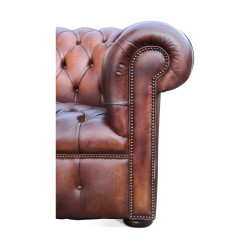 Un canapé "Chesterfield" en cuir, patine marron. Restauré