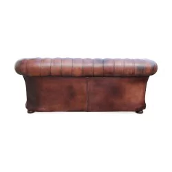 Un canapé "Chesterfield" en cuir, patine marron. Restauré