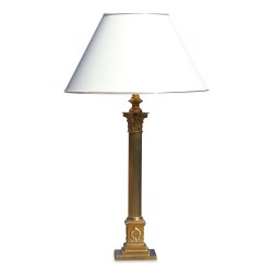 A brass Corinthian column lamp with white shade