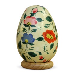 A Russian wooden egg with floral decoration on a cream background