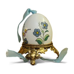 A porcelain egg with floral decoration on a gilded bronze base