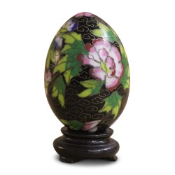 A cloisonné egg with floral decoration on a black background