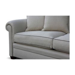 A three-seater \"Bahamas\" sofa covered in beige linen fabric and gray piping