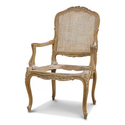 Un fauteuil de style Louis XV en Hêtre, richement sculptée. Dossier cané. Modèle