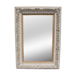 Ein Spiegel mit abgeschrägter Kante und kunstvoll geschnitztem, weiß lackiertem Eichenholzrahmen