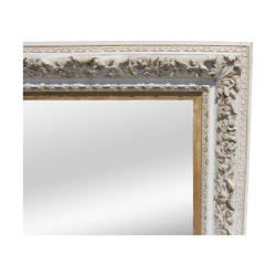 A mirror with beveled edge and ornately carved oak wood frame painted white