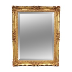 A mirror with beveled glass and richly molded gilded frame