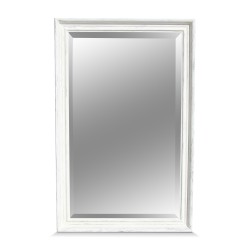 A mirror with beveled glass and white wooden frame
