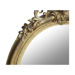 A richly molded Napoleon III oval mirror in gilded wood, mercury glass