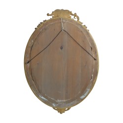 A richly molded Napoleon III oval mirror in gilded wood, mercury glass