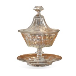 A glass cup with lid and stand.