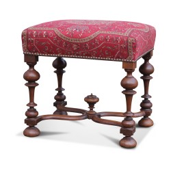 Une assise de style Louis XIV en noyer, entretoise et recouvert d’un tissu rouge cachemire